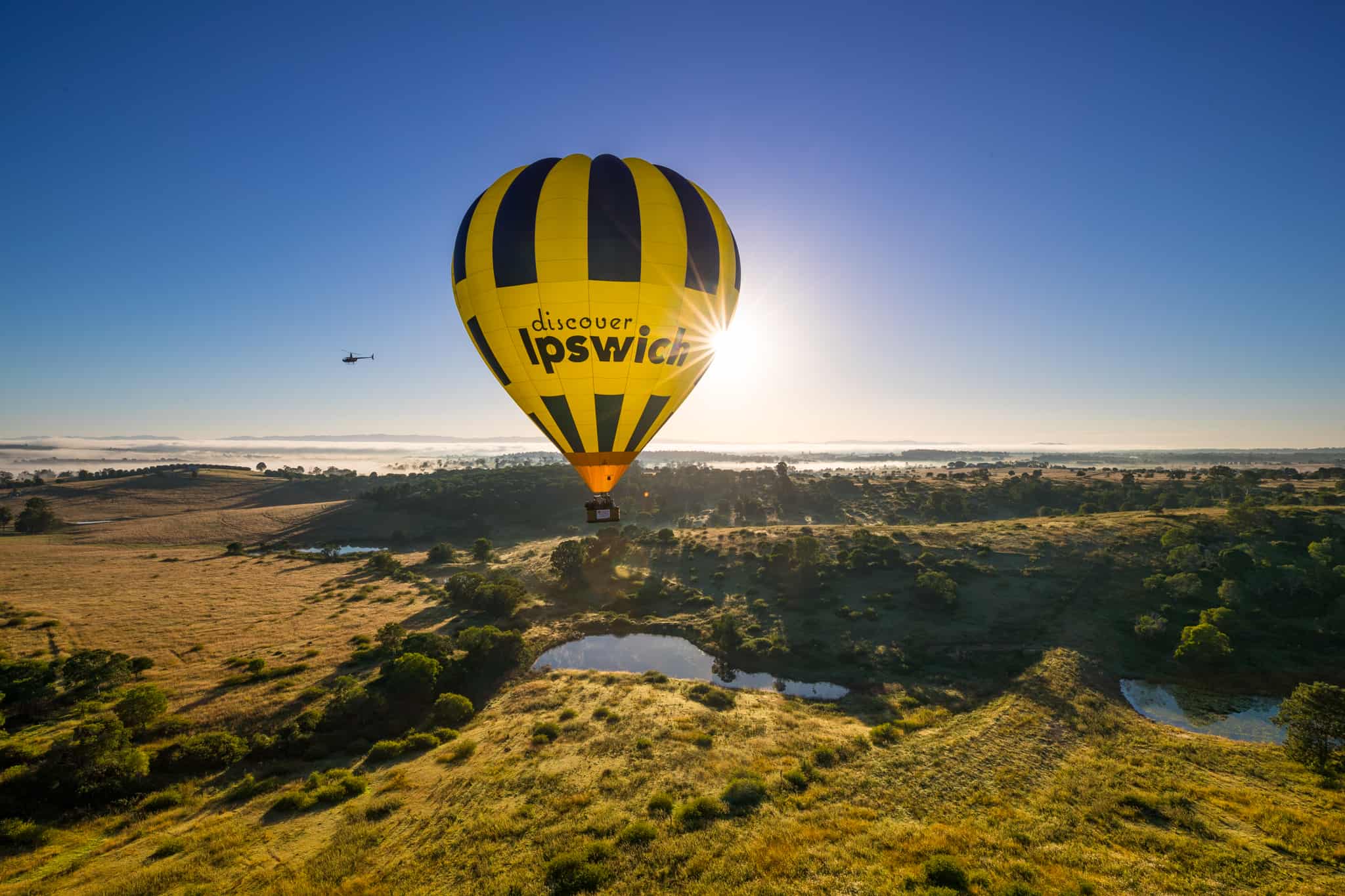 Hot air balloon flying over countryside Hot air balloon flying over countryside