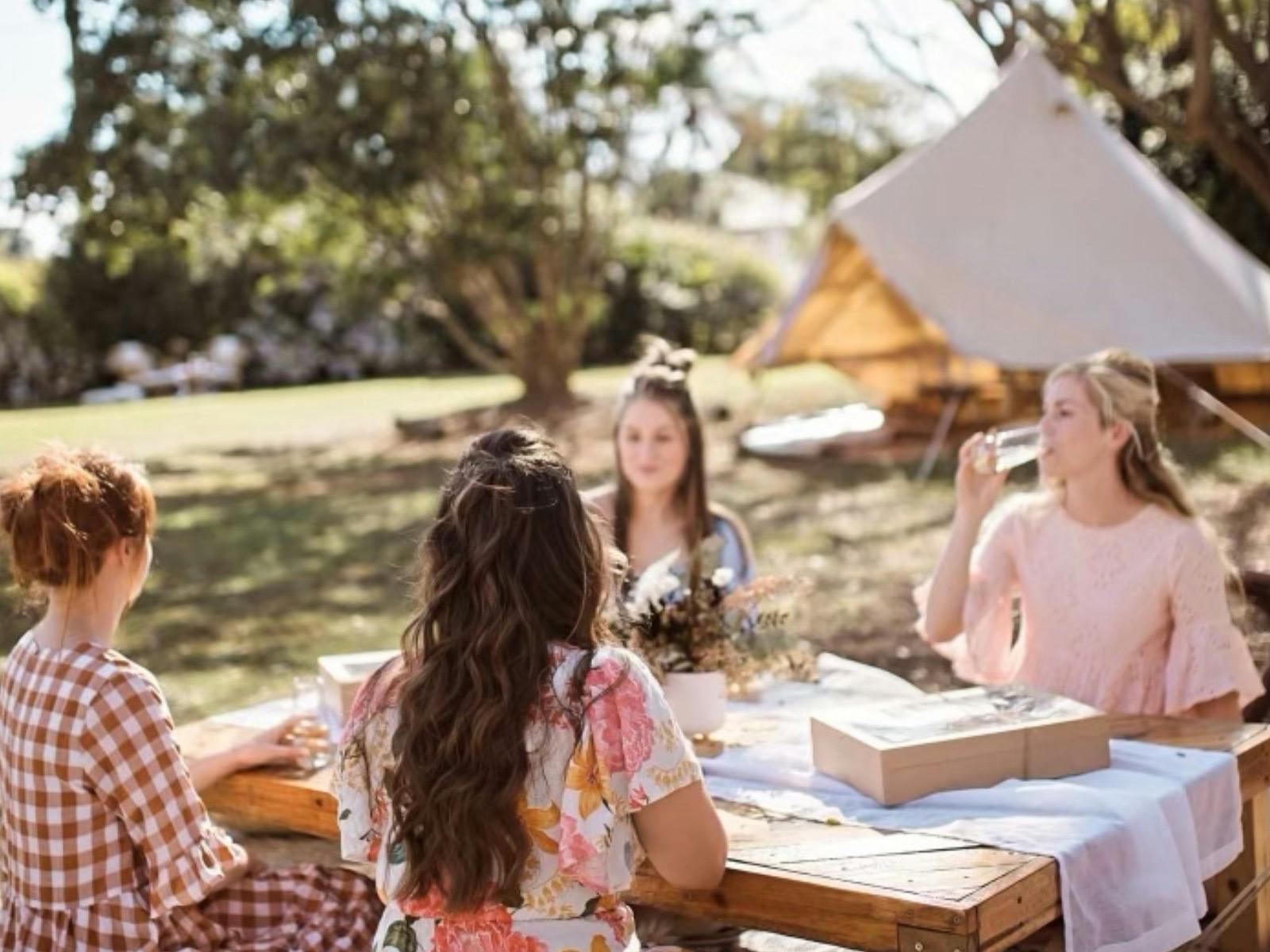 Group of ladies sitting around our bespoke sunshine styled picnic at The Soul Nook Group of ladies sitting around our bespoke sunshine styled picnic at The Soul Nook