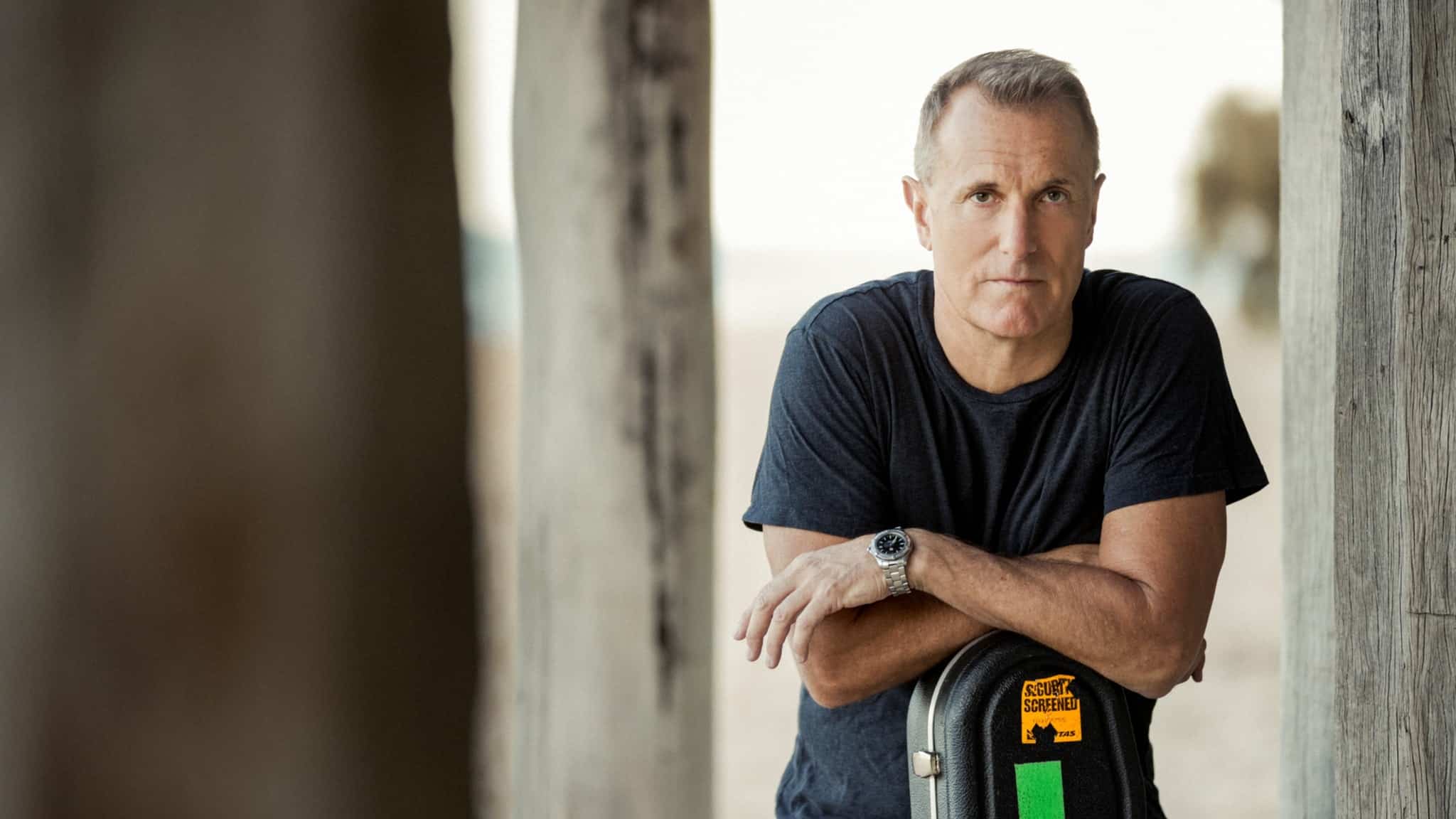 James reyne leaning on his guitar case