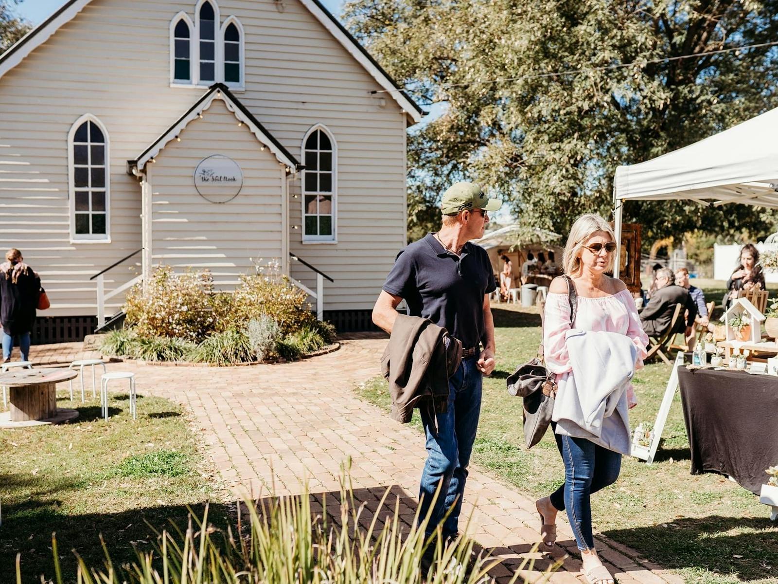 Picture of the Front of the Soul Nook store, with markets to the side and people walking around.